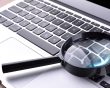 Magnifying glass placed on a laptop keyboard