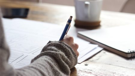 Person completing paper form with pen
